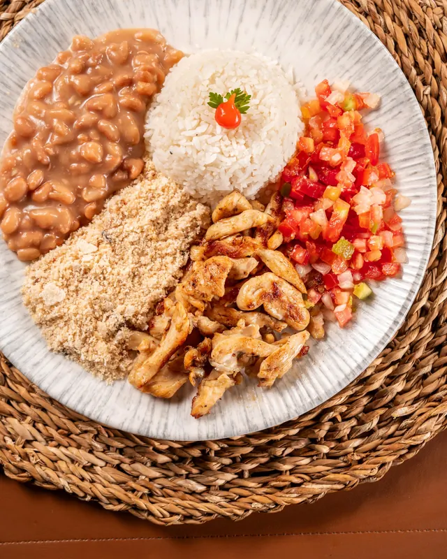 Prato executivo visto de cima, com arroz, feijĂŁo, farofa, vinagrete e tiras de frango